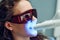 Laser bleaching teeth at dantist room. Teeth whitening for woman. Bleaching of the teeth at dentist clinic