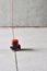 Laser level measuring tool in construction site on the floor in the empty concrete room - picture