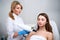 Laser mole removal on a woman`s chest in a beauty salon. Hardware cosmetology. Pretty blonde beautician doctor removing