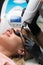 Laser removal of permanent makeup. The beautician removes the tattoo from the eyebrows