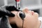 Laser removal of permanent makeup eyebrow of young woman in salon