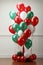 lassic red and green balloon display set against a snowy background.