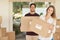 These are the last boxes. Portrait of a smiling young couple carrying boxes while moving into their new home.