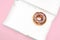 Last chocolate donut in empty box on pink background