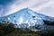 Last gleam of winter daylight on a snowcapped peak of Mount Taranaki