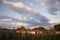 The last ray of the sun illuminates the beautiful clouds and white houses