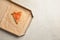 Last slice of cheese pizza in cardboard box on grey table, top view with space for text.