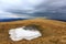 Last snow on meadow in mountains