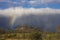 Late afternoon storm with rainbow at leading edge.