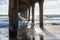 Late afternoon sun underneath the Manhattan Beach Pier along the Pacific Ocean coastline in Southern California