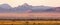 A late-afternoon, wide-cropped, view of the plains and hills dotted around the Namib-Naukluft Nature area in Namibia.