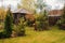 Late autumn garden view with wooden shed and conifers