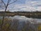 Late autumn on the river: Look across the river on a late fall day  bare tree branches