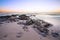 Late evening landscape of ocean over rocky shore with clouds blowing