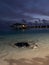 Late evening in the Maldives. Overwater villas with lights on, azure Indian Ocean waters with stingrays and little sharks swimming