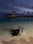 Late evening in the Maldives. Overwater villas with lights on, azure Indian Ocean waters with stingrays and little sharks swimming