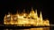 During the late hours the panoramic facade of the Hungarian Parliament in Budapest. The building is all lit.