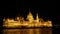 During the late hours the panoramic facade of the Hungarian Parliament in Budapest. The building is all lit.