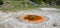 Late Spring in Yellowstone National Park: Vividly Colored Economic Geyser of the Grand Group in Upper Geyser Basin