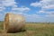 late summer hay straw in a bale stack in a meadow mowed field. Grain harvesting time. Growing bread grains