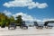 Late summer view of sun-beds chairs on a stone patio with water and horizon in the background