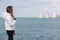 Late teen girl observing yacht regatta in windy day
