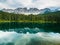 Latemar mount and woods reflected in Karersee lake, Dolomites, Italy