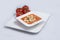 A lateral Hero Shot of a Tomato Soup with bread crumbs, oregano on a minimal white background with a diagonal 45 angle