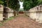 Laterite stone paved walkway with free-standing stone posts to the gates of ancient Khmer temple built of red sandstone and lateri