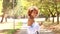 Latin african american woman walking smiling with mobile phone looking at camera