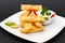 Latin-American appetizers called Tequenos made of fried wonton filled with cheese and is served with guacamole