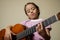 latin american colombian girl practices music on her acoustic guitar