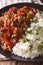 Latin American cuisine: ropa vieja with rice close-up. vertical