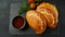 Latin American fried empanadas with tomato sauce. Argentinian Empanada is a pastry turnover filled with a variety of savory
