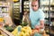 Latin American man choosing vegetables and fruits in grocery store