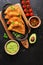 Latin American, Mexican, Chilean food. Traditional fried empanadas served with tomato and avocado sauce on a dark background. Top