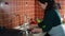 Latin American pregnant woman washes spinach leaves and veggies under tap in sink. Healthy nutrition