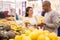 Latin american woman choosing ripe bananas in supermarket with his boyfriend