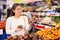 Latin american woman choosing ripe tomatoes in supermarket