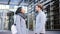 Latin business woman walking to have a handshake greeting with a coworker or client man. Two colleague talking at the