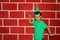 Latin child happy and excited for the arrival of December and celebrating Christmas shows his enthusiasm with hat and green Christ