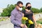 Latin Couple in mourning cemetery holding yellow flowers in their hands