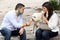 latin couple with protection mask sitting accompanied by white labradoodle dog eating ice cream