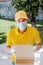 Latin delivery man with mask holding and carrying a cardbox in quarantine coronavirus pandemic