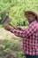 Latin Farmer working in the orchard, checking his work equipment