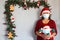 Latin grandmother with protection mask and santa claus hat, christmas decoration and santa claus doll, new normal covid-19