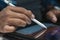 Latin graphic designer working in his office on an illustration tablet, he wears a blue checkered shirt and glasses