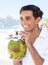 Latin guy enjoying coconut water at beach