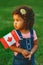 Latin hispanic baby toddler girl holding waving Canadian flag.
