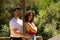 Latin lovers couple leaning on a wooden poster in a sensual way. The man is camouflaging the woman to make her fall in love. They